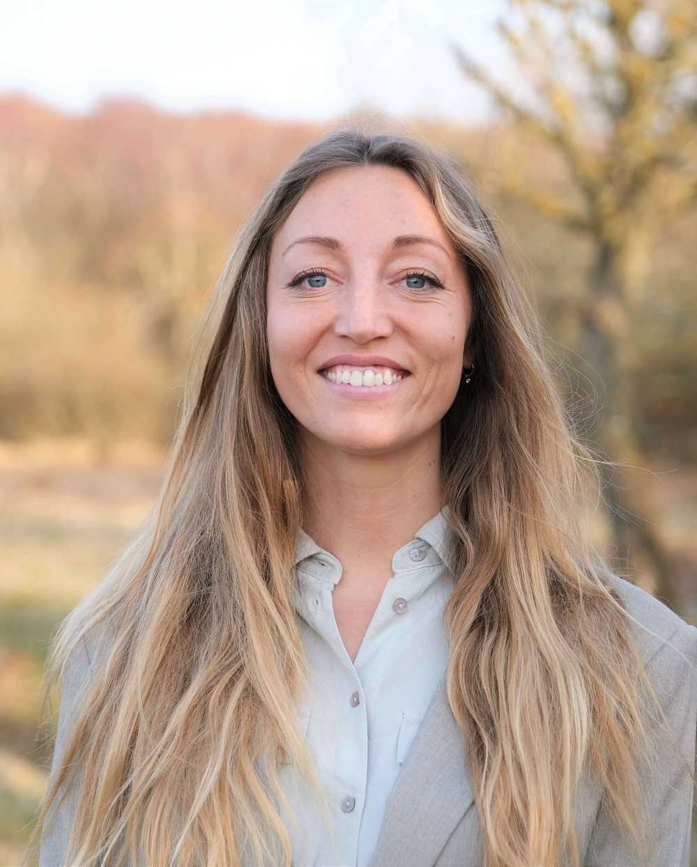 A portrait of a female Aurobay employee smiling at the camera